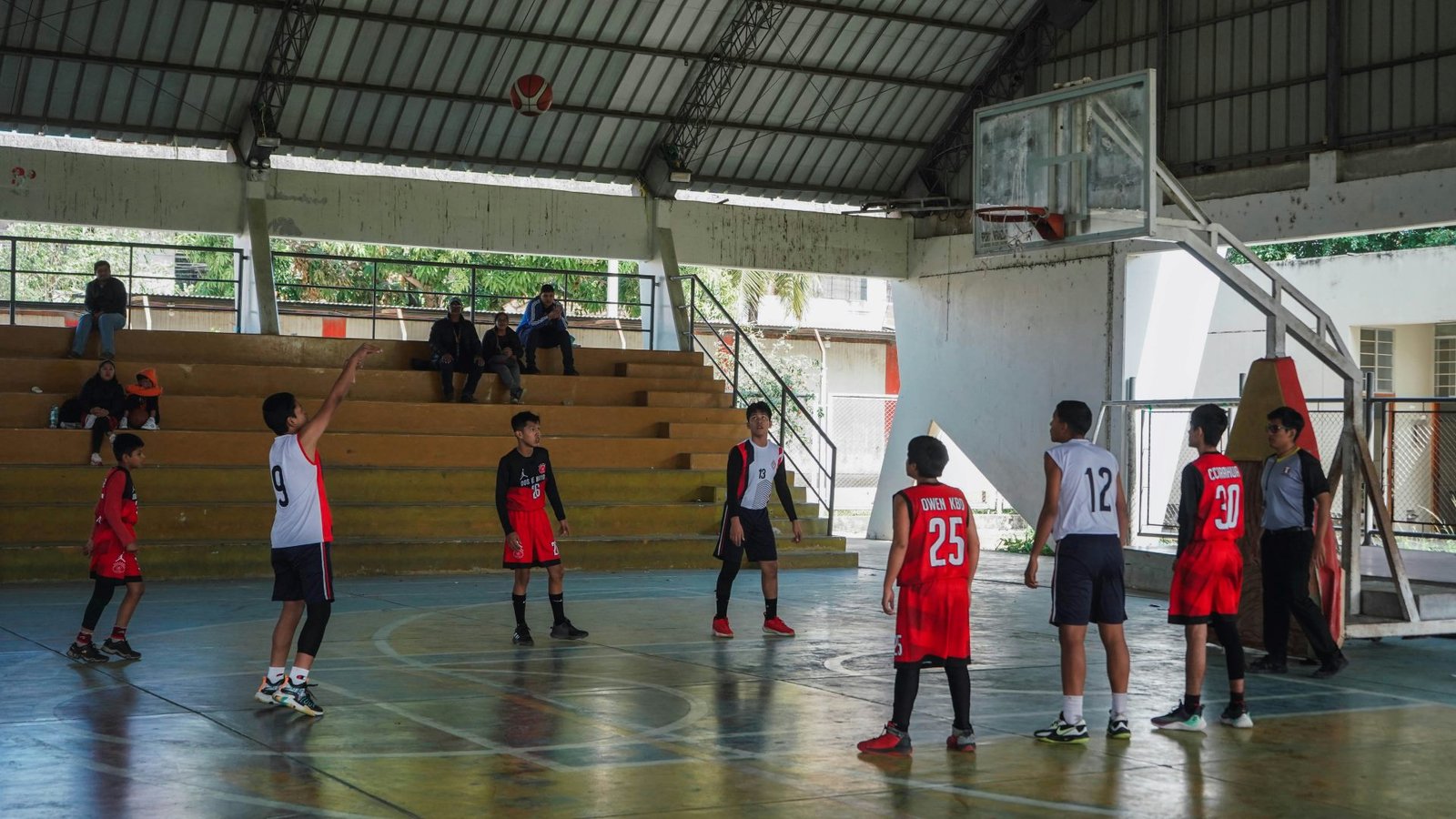 A young basketball player taking a free throw during a youth match.